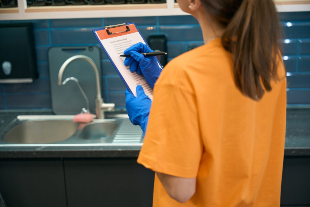 Cleaning company worker checking list cleaned areas in coworking space